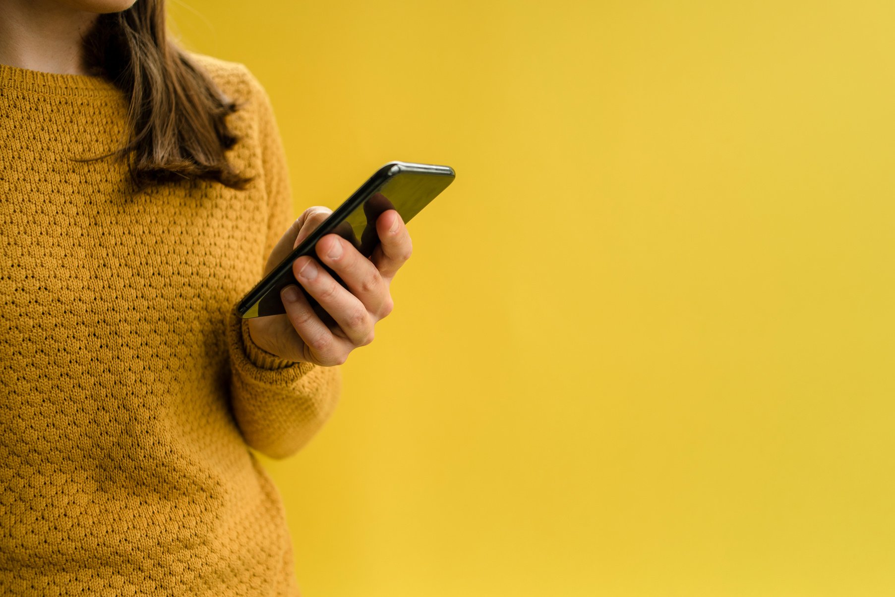 Woman in Yellow Sweater Using Smartphone